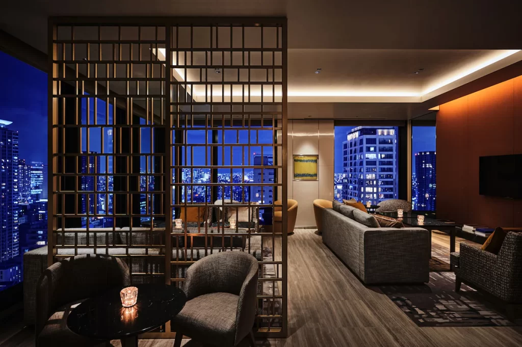 best hotels in Osaka with toddlers. photo of elegant high rise hotel lobby with skyline in background at night.