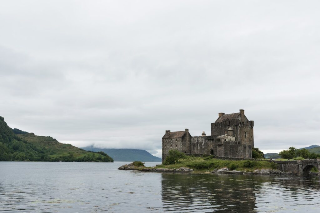 brown brick castle surrounded with body of water Eilean Donan Castle