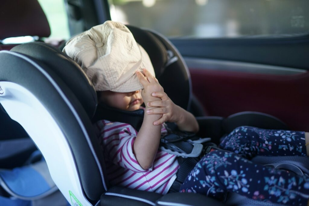 A child has a bag over their head in car.
