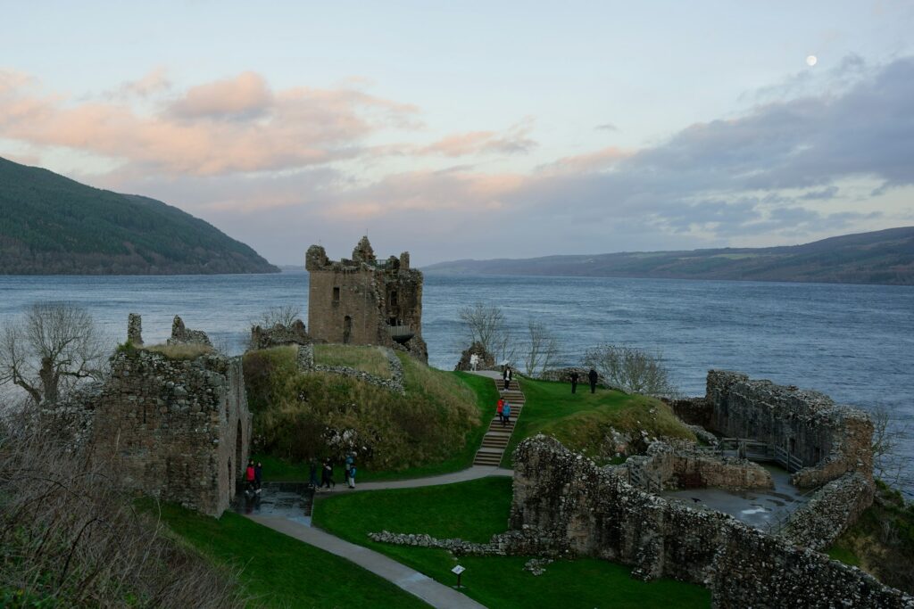 a castle on a hill overlooking a body of water in Scottish Highlands