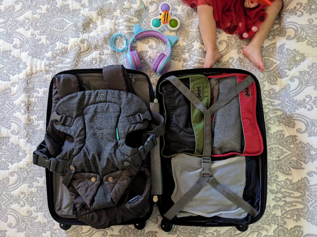 packing cubes in a suitcase with a baby carrier