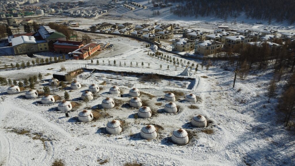 an aerial view of a village in the snow