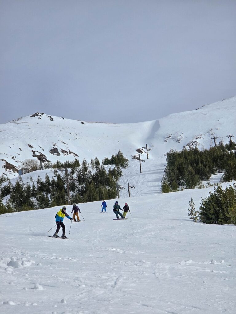 A group of people riding skis down a snow covered slope