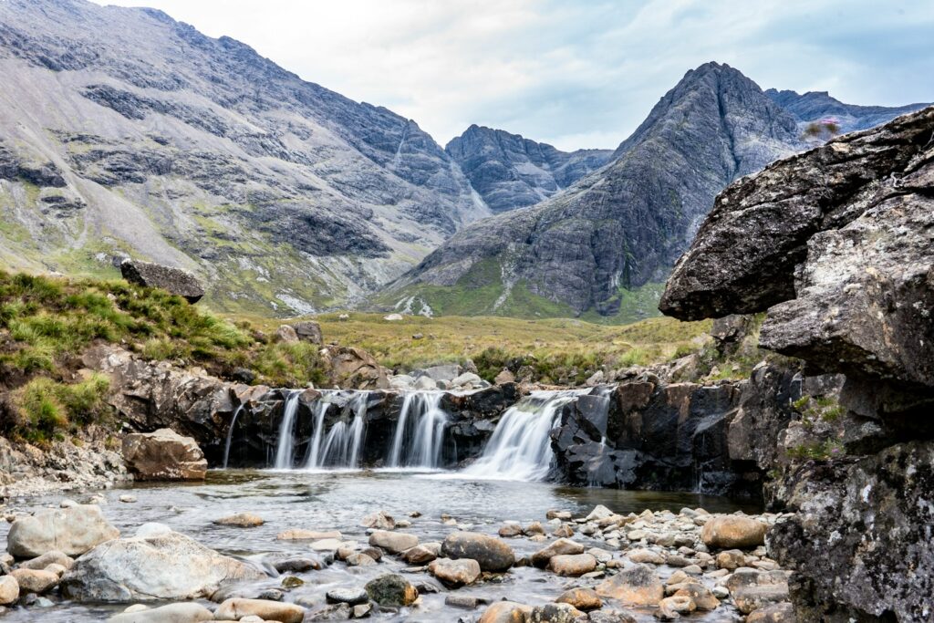 a small waterfall in the middle of a mountain stream