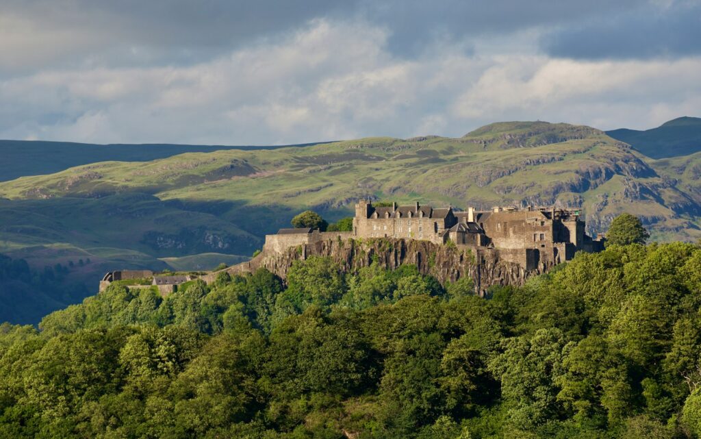 a castle sitting on top of a lush green hillside