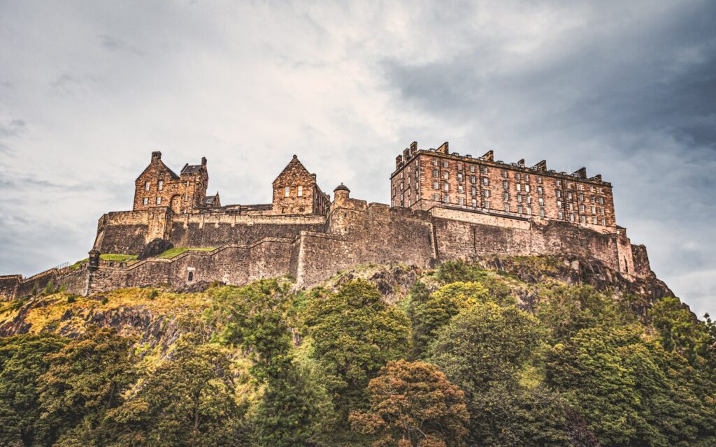 a castle on top of a hill surrounded by trees