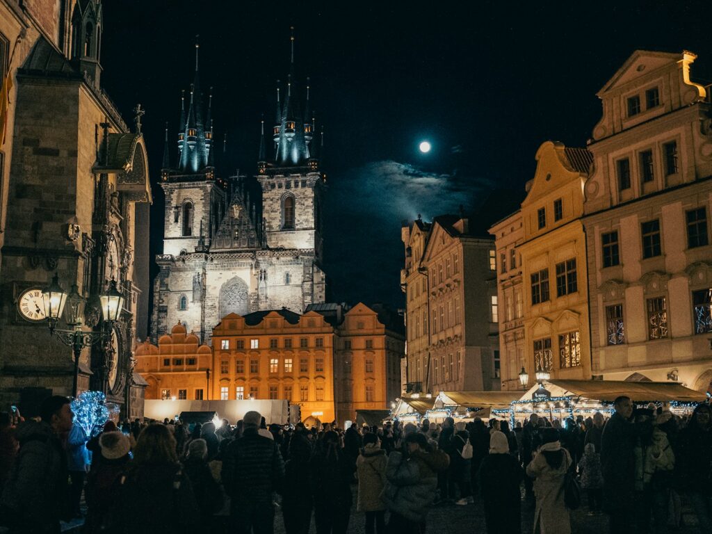 A crowd of people standing around a city at night