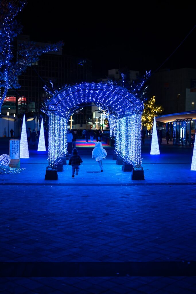 A group of people walking through a park at night